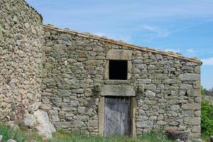 pedra casa parede com aberto janela e velho de madeira porta foto