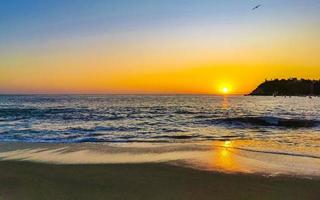 colorido pôr do sol dourado grande onda e praia puerto escondido méxico. foto