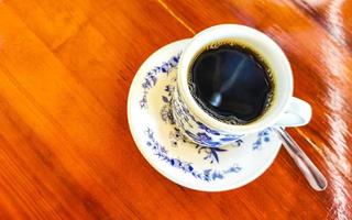 pote de xícara branca azul com mesa de madeira de café preto méxico. foto