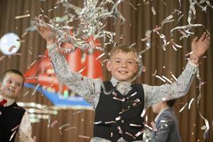 feliz pequeno Garoto dentro confetti.magic Tempo - retrato do uma muito feliz criança com mãos sorridente enquanto queda confete. às uma crianças Festa. foto