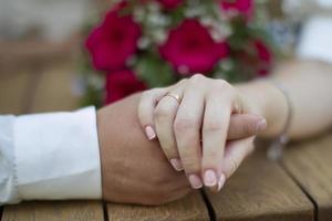 casamento e amar. masculino e fêmea mão com uma Casamento anel. foto