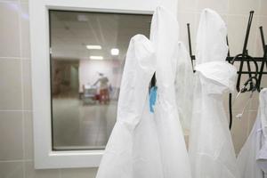 branco médico vestidos aguentar em cabides dentro a hospital. foto