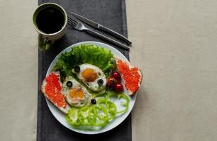 café da manhã, mexidos ovos em alface folhas, Próximo para fresco legumes e uma sanduíche com vermelho caviar foto