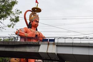 nova delhi, índia - 21 de junho de 2022 - grande estátua de lord hanuman perto da ponte do metrô de delhi situada perto de karol bagh, delhi, índia, lord hanuman grande estátua tocando o céu foto