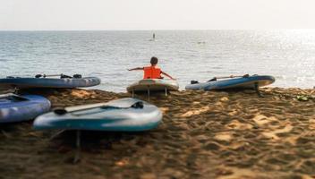 chon buri, tailândia, 14 novembro 2022.pouco Garoto jogando em a de praia às a pôr do sol tempo. pessoas tendo Diversão ao ar livre. conceito do feliz e inspiração, chon buri província, tailândia. foto