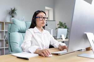 conectados distância aprendizado. ásia professor dentro fones de ouvido sentado às uma mesa ensino uma lição conectados foto