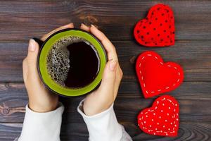 composição de dia dos namorados com xícara de café e coração de veludo vermelho. vista do topo. espaço de cópia foto