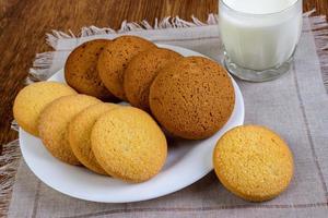 comida, junk-food, culinária, cozimento e conceito de alimentação - close-up biscoitos de aveia e copo de leite foto