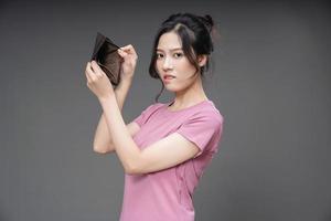 jovem ásia mulher segurando esvaziar carteira em fundo foto