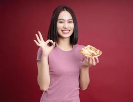 jovem ásia mulher comendo pizza em fundo foto