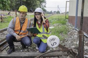 dois engenheiro trabalhando às trem estação, trabalho juntos felizmente, ajude cada de outros analisar a problema, consulte sobre desenvolvimento orientações foto