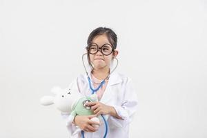 Ásia pequeno menina jogando médico isolado em branco foto