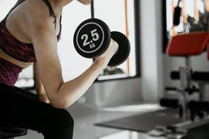 fitness mulher em treinamento com forte abdômen aparecendo na academia foto
