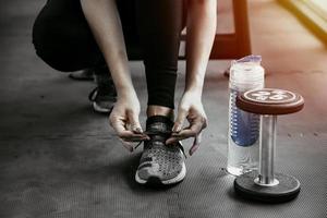 mulher amarrando os cadarços. close-up de corredor de fitness de esporte feminino se preparando para correr na academia foto