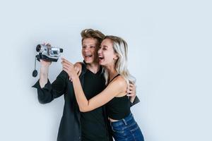 retrato feliz de casal segurando uma câmera de vídeo e gravando um vídeo