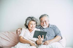 casal de idosos usando um computador tablet foto