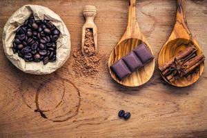 café, chocolate, especiarias em madeira surrada foto