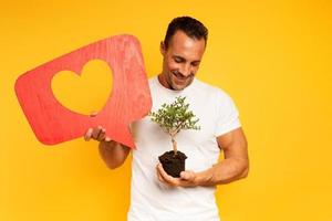 feliz homem curtidas uma pequeno árvore pronto para estar plantado. conceito do florestação foto