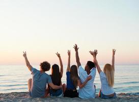 grupo do amigos tendo Diversão em a de praia foto