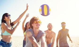 grupo do amigos jogando às de praia voleio às a de praia foto