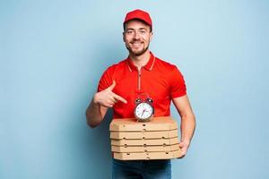 entregador é pontual para entregar rapidamente pizzas. ciano fundo foto