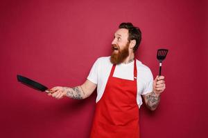 feliz chefe de cozinha cozinheiros uma Novo criativo receita. vermelho fundo foto