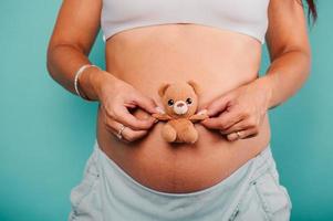 grávida mulher esperando uma criança carícias dela barriga foto