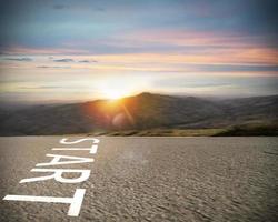 começar escrito para a terra em uma estrada às pôr do sol. conceito do Novo começando e iniciando Novo oportunidades foto