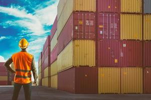 homem às trabalhos entre containers dentro uma comercial porta foto