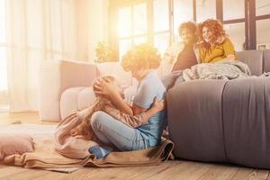 feliz família jogar juntos às casa em sofá. conceito do União, amor, afeição foto