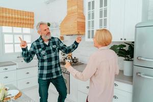 marido e esposa dança às casa durante café da manhã foto