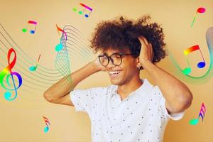 feliz afro homem danças e escuta para música foto