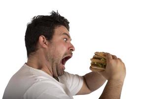 insaciável e com fome homem comendo uma sanduíche foto