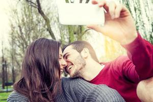 agradável casal namorados leva uma selfie relaxante em espreguiçadeira ao ar livre foto