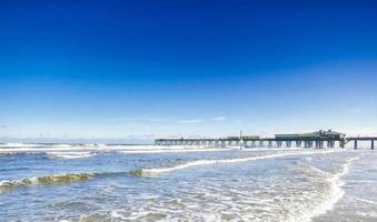 doca de madeira com ondas do mar em daytona beach, florida foto