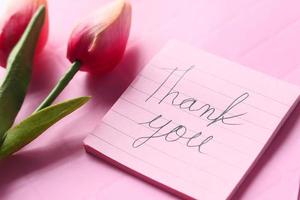 mensagem de agradecimento com flor de tulipa em fundo rosa foto