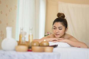 jovem mulher bonita com massagem saudável em um salão de spa foto