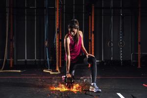 Atlético menina trabalho Fora às a Academia com uma fogosa kettlebell foto