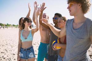 grupo do amigos jogando às de praia voleio às a de praia foto