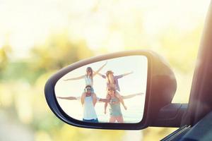 asa espelho do uma carro com refletido uma grupo do amigos foto