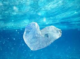 flutuando bolsa. problema do plástico poluição debaixo a mar conceito. foto