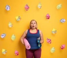 gordo menina pensa para comer doces em vez de do Faz academia. amarelo fundo foto