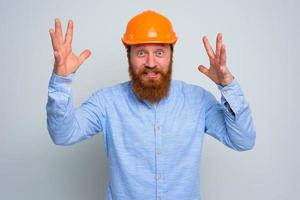 isolado feliz arquiteto com barba e laranja capacete foto