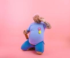 gordo homem atos gostar uma bebê mas bebidas Cerveja foto