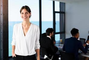 confiante empresária dentro escritório com dele trabalho em equipe. conceito do cooperação foto