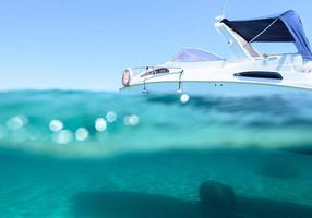 barco flutua dentro uma cristalino e transparente mar foto