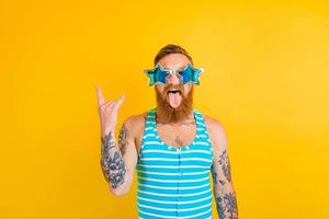 homem com barba, tatuagens e roupa de banho é pronto para a verão foto