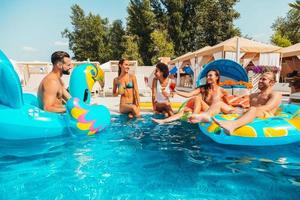 grupo do amigos dentro roupa de banho apreciar dentro uma natação piscina foto