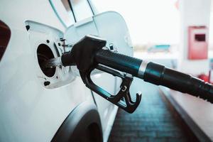 combustível bomba preencher uma tanque do uma carro dentro uma estação foto