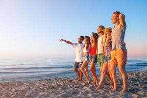 grupo do amigos tendo Diversão em a de praia foto